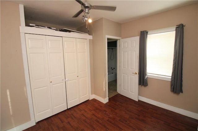 unfurnished bedroom with dark wood-style floors, a closet, baseboards, and a ceiling fan