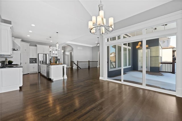 kitchen with an inviting chandelier, hanging light fixtures, tasteful backsplash, white cabinets, and a kitchen island