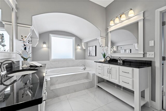 bathroom with vanity and a relaxing tiled tub