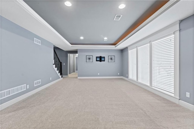 interior space featuring light carpet and a raised ceiling