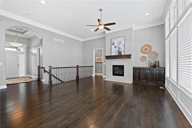 unfurnished living room featuring dark hardwood / wood-style flooring, plenty of natural light, and ornamental molding