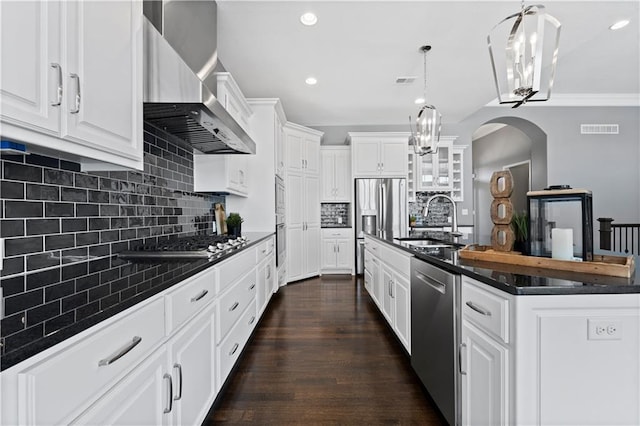 kitchen featuring sink, wall chimney exhaust hood, white cabinets, and appliances with stainless steel finishes