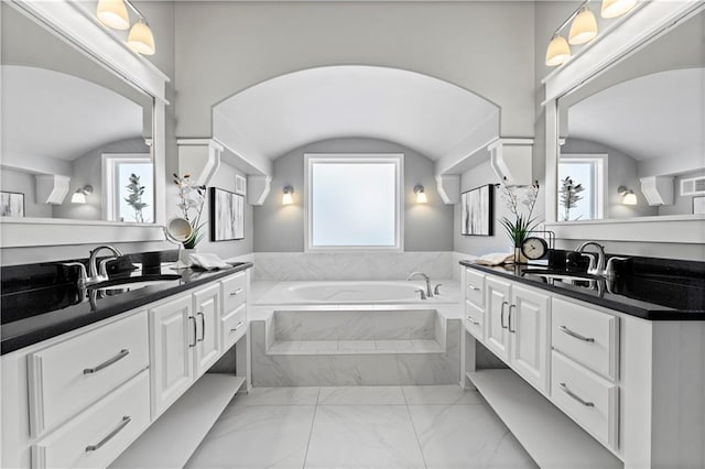 bathroom featuring vanity and tiled tub