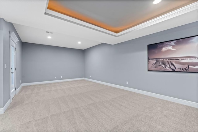 unfurnished room featuring light carpet and a tray ceiling