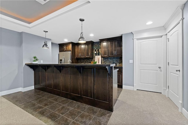 kitchen with dark brown cabinets, a kitchen breakfast bar, stainless steel fridge with ice dispenser, and hanging light fixtures