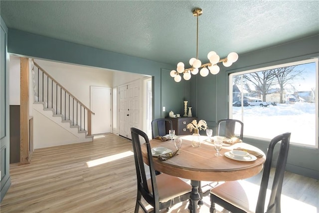 dining area featuring wood-type flooring and a textured ceiling