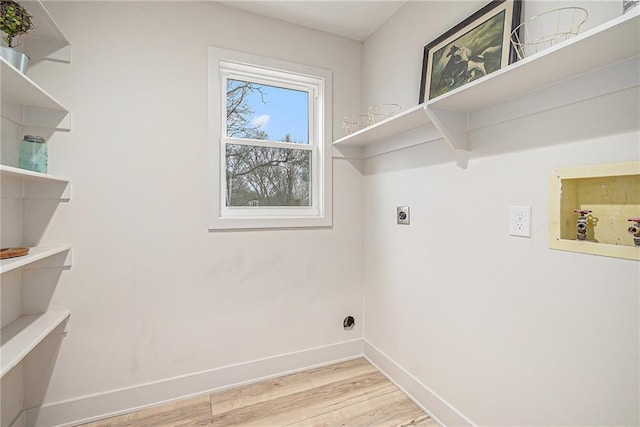 washroom featuring electric dryer hookup and light hardwood / wood-style flooring