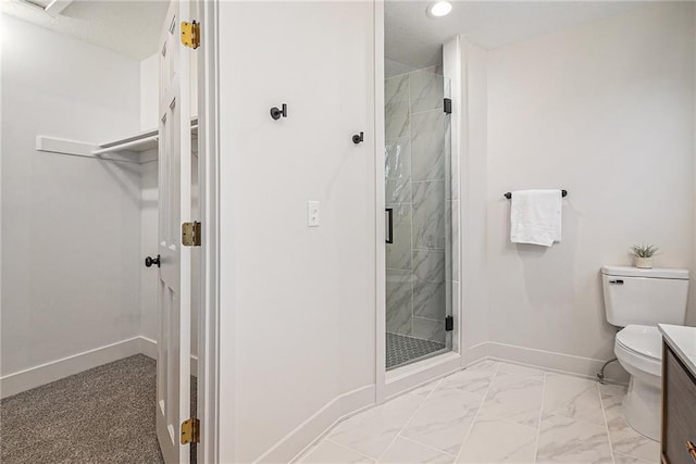 bathroom featuring a shower with door, vanity, and toilet