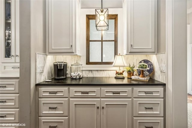 bar featuring white cabinetry, tasteful backsplash, and hanging light fixtures