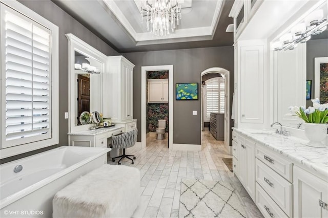 bathroom featuring toilet, crown molding, vanity, a tray ceiling, and a notable chandelier