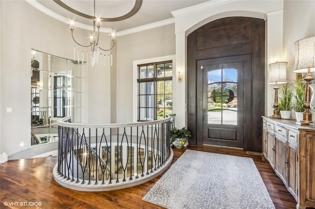 entrance foyer featuring ornamental molding, dark hardwood / wood-style floors, and a notable chandelier