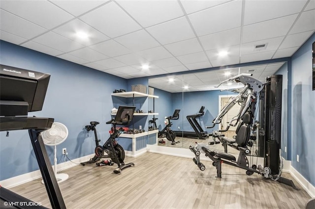 workout room with a drop ceiling and hardwood / wood-style flooring