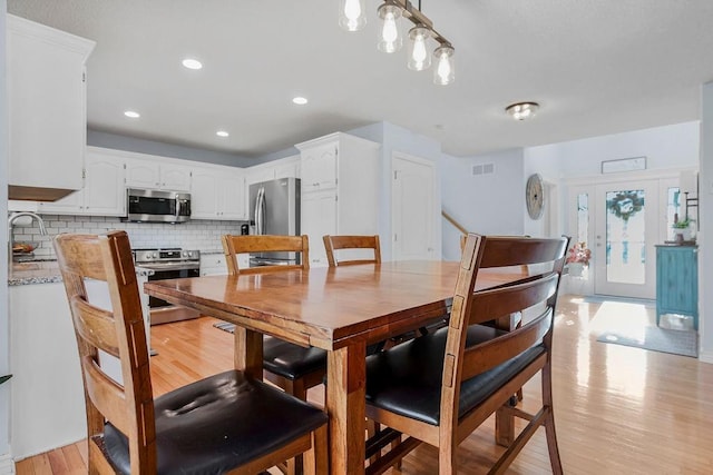 dining space with french doors and light wood-type flooring