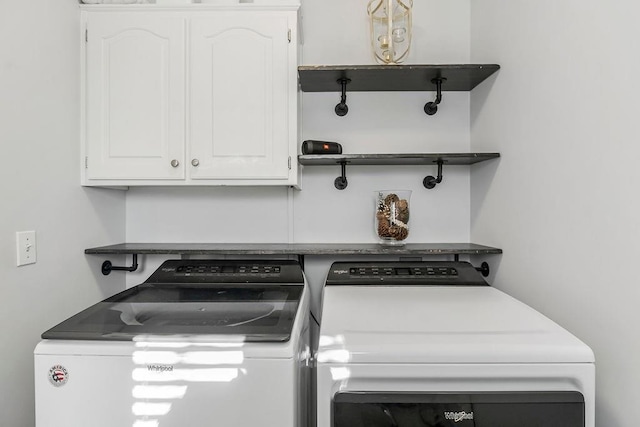 laundry room with washing machine and dryer and cabinets