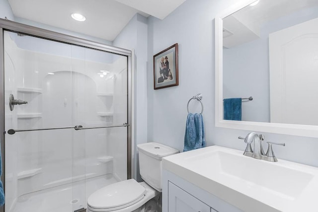 bathroom featuring vanity, toilet, and a shower with shower door