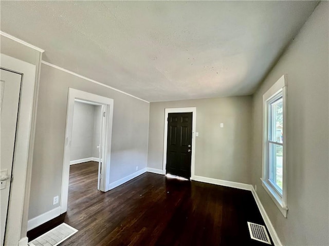 unfurnished room featuring dark hardwood / wood-style flooring and plenty of natural light