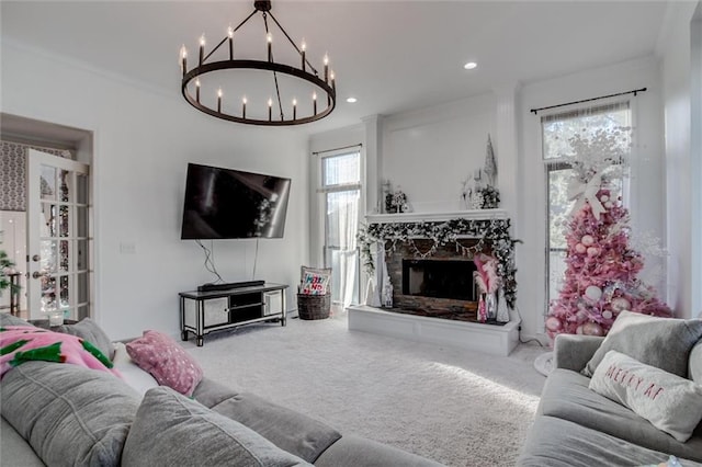 carpeted living room featuring ornamental molding and a chandelier