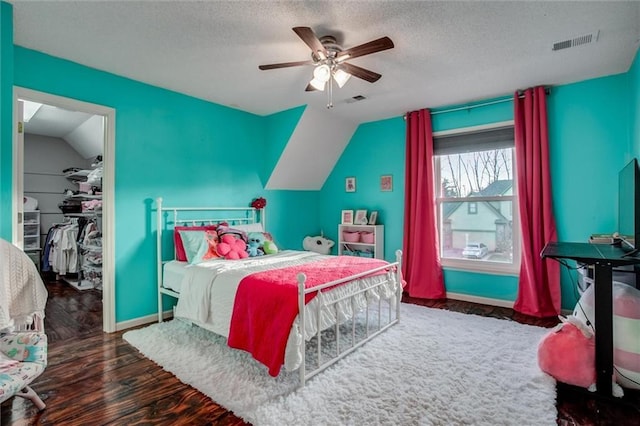 bedroom featuring ceiling fan, dark hardwood / wood-style flooring, lofted ceiling, and a closet