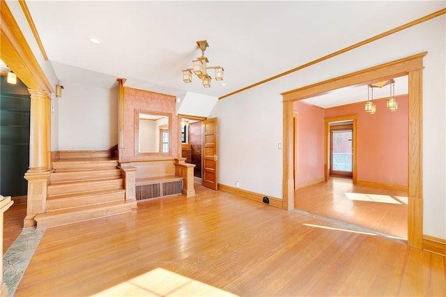 living area with stairway, wood finished floors, decorative columns, and baseboards