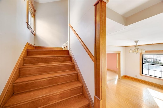 stairs with visible vents, baseboards, and wood finished floors