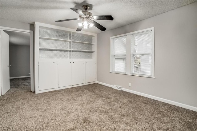 unfurnished bedroom featuring ceiling fan, a closet, light carpet, and a textured ceiling