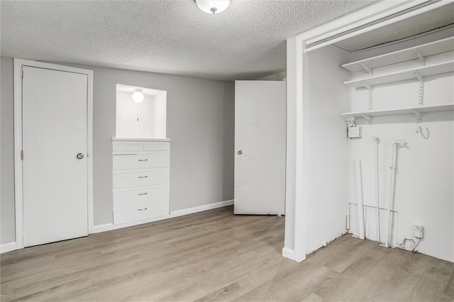 unfurnished bedroom featuring light wood-type flooring and a textured ceiling