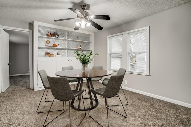 carpeted dining room with ceiling fan, built in features, and a textured ceiling