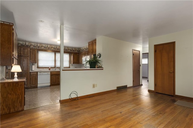 kitchen with dishwasher and light hardwood / wood-style floors