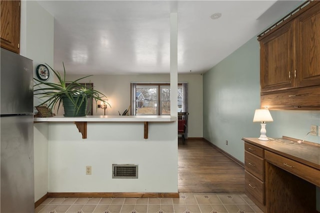 kitchen featuring a kitchen breakfast bar and stainless steel fridge