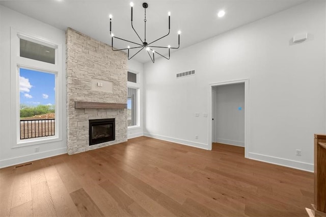 unfurnished living room featuring a high ceiling, visible vents, baseboards, and wood finished floors