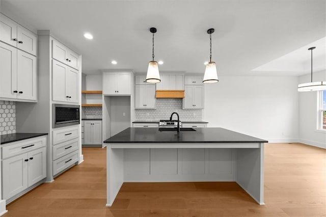 kitchen with recessed lighting, a sink, dark countertops, and tasteful backsplash