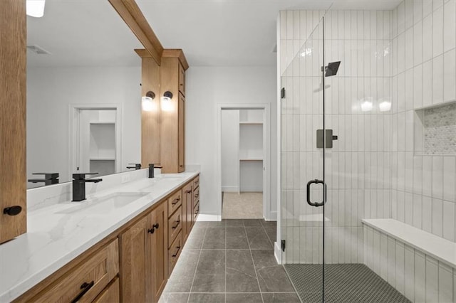full bath featuring double vanity, visible vents, tile patterned flooring, a stall shower, and a sink