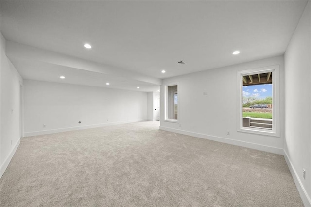 spare room with baseboards, recessed lighting, and light colored carpet