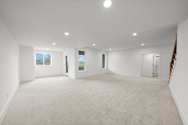 basement featuring stairway, recessed lighting, and light colored carpet