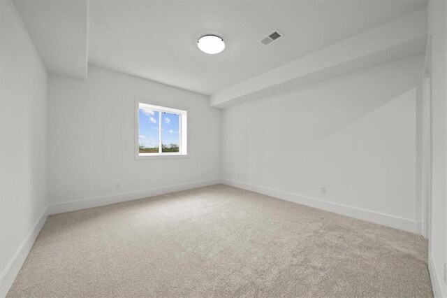 empty room featuring baseboards, visible vents, and carpet