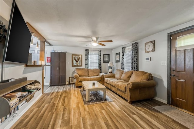 living room featuring light wood-type flooring and ceiling fan