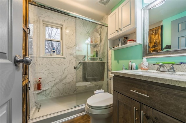 bathroom with vanity, toilet, a shower with door, and wood-type flooring