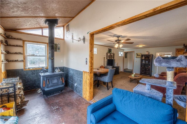 living room with ceiling fan and a wood stove