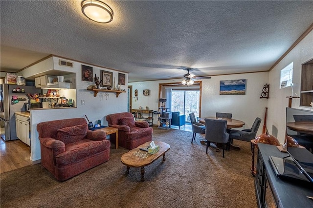 living room featuring carpet flooring, crown molding, ceiling fan, and a textured ceiling