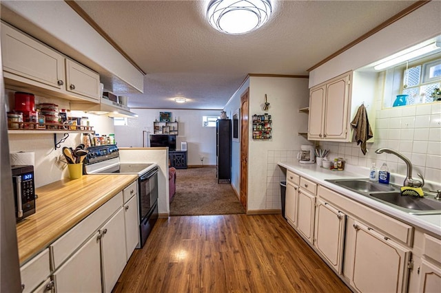 kitchen featuring black appliances, ornamental molding, sink, and hardwood / wood-style floors