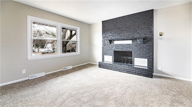 unfurnished living room with carpet flooring and a brick fireplace