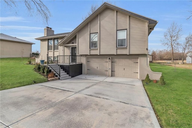 back of house with a garage and a lawn