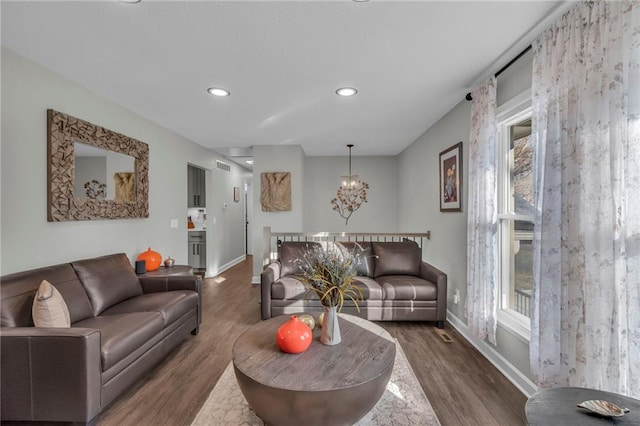 living room with dark hardwood / wood-style floors, a chandelier, and a wealth of natural light