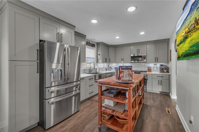 kitchen featuring tasteful backsplash, appliances with stainless steel finishes, and gray cabinetry