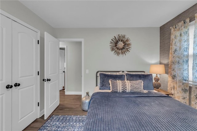 bedroom with dark wood-type flooring and a closet