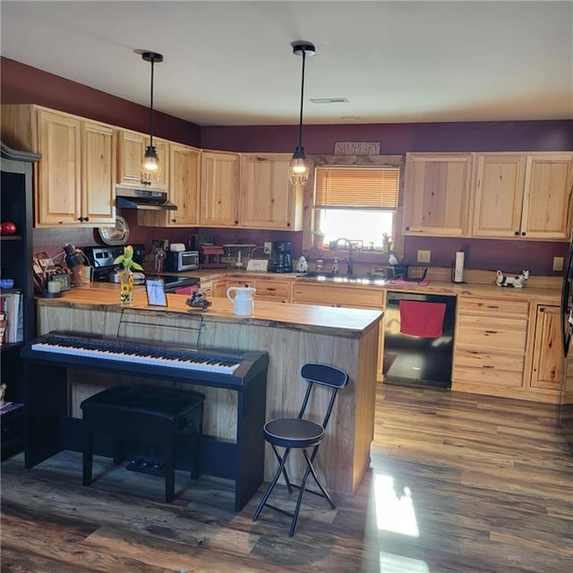 kitchen featuring sink, hanging light fixtures, black dishwasher, stainless steel electric range, and a breakfast bar area