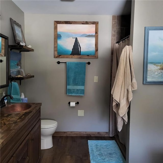 bathroom with a shower with shower curtain, vanity, hardwood / wood-style flooring, and toilet