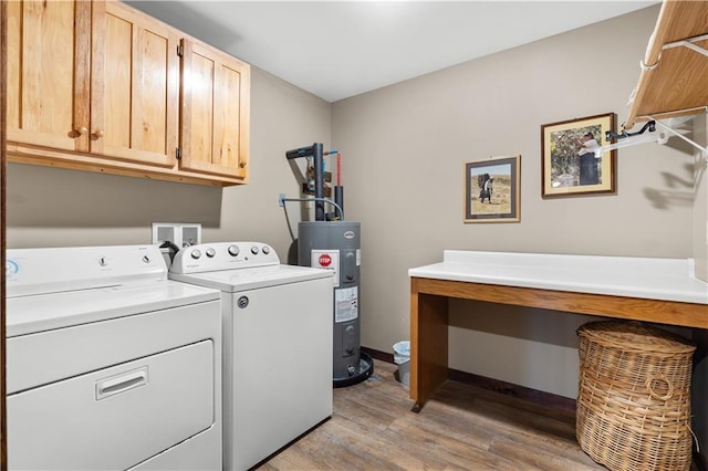 laundry area featuring independent washer and dryer, cabinets, electric water heater, and light hardwood / wood-style flooring