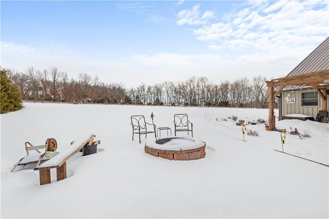 yard layered in snow with a fire pit and a pergola