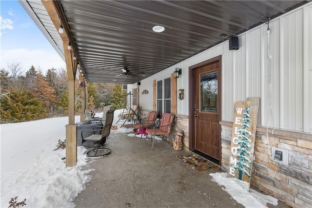 snow covered patio featuring ceiling fan